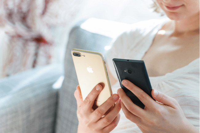 kvinna håller i en iphone och en android-telefon